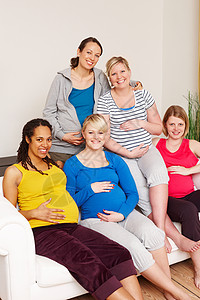 一群孕妇一群多种族孕妇坐在沙发上 对着镜头微笑 笑声 我们无法等待大日子的到来产妇长椅母亲女士团体幸福福利腹部运动服产前班背景