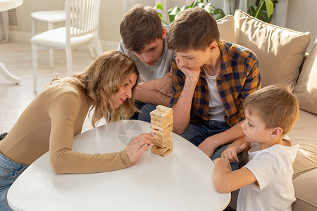 棋盘塔家庭 在房间里玩一个木制矩形区块组成的棋盘游戏背景