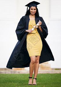 毕业日的一位年轻女子在毕业日持有毕业证书 她的形象令人着迷 引人瞩目背景图片