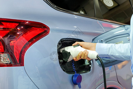 车辆加油通过可充电电力机用EVcar充电充电电池的亚洲近身女性手背景