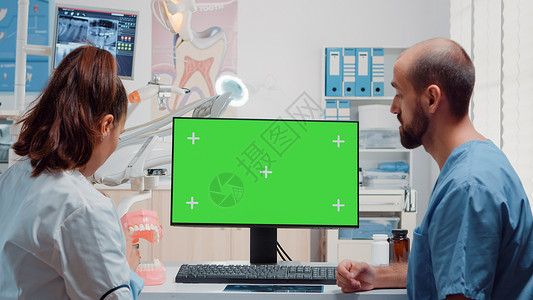 护士个人简历模板牙科医生和护士在计算机上分析绿色屏幕背景