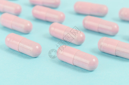 蓝色背景的粉色胶囊药丸处方行业医药疗法互联网抗生素止痛药保健诊所消毒图片