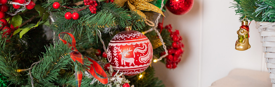 圣诞球挂在白雪皑皑的枞树上 许多五颜六色的球花环发光的灯和树枝上的红色浆果洒上了雪 喜庆的传统装饰季节家居卡片风格装饰品玩具金子背景图片