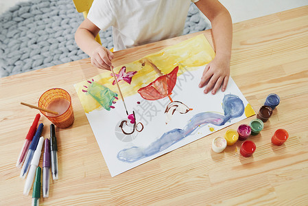 来咯短短的片刻和图片将会完成 小女孩正在通过使用古阿希和刷子来画画 在艺术课上学习背景