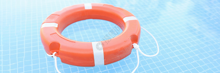 游泳救生圈在泳池闭合中漂浮的橙色塑料活性胶背景