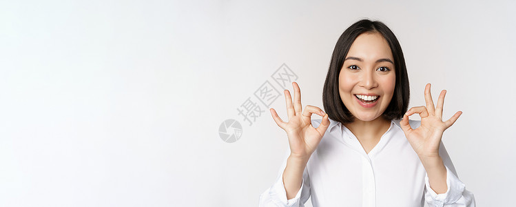 好物推荐头像特写亚洲女孩的头像 表现出好的 好的手势和满意的微笑 推荐 高兴 赞美和恭维 白色背景企业家工作室售货员老板手臂女性人士商务女士背景