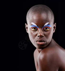 狂野非洲一种狂野而多彩的精神 一个漂亮的模特在黑色背景上摆着五颜六色的眼妆的工作室肖像背景