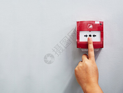 火警按钮启动警报器 有人在墙上按着火警铃被割伤背景