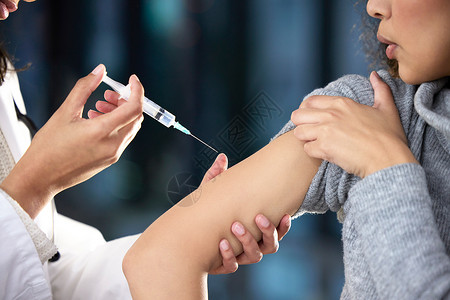 它只会伤害几秒钟 一名妇女在 Covid-19 疫苗接种中心接受注射的照片背景图片