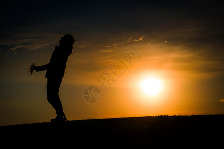 三鹰之森黄昏时站在山丘上的男人的休眠三鹰背景男性阴影爬坡草原例子日落天空太阳背景