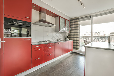 红色橱柜红色音调小厨房的内部火炉风格厨具橱柜装饰台面凳子奢华房子内阁背景