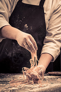 做意大利面厨师从头做新鲜意大利面条面粉中心职业厨房木头台面烘烤食物学习人体背景