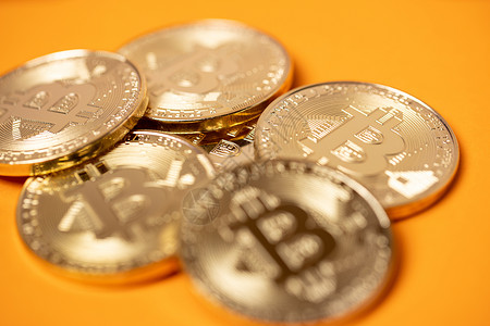 橙色背景的比特币硬币 加密货币硬币概念和连锁技术 金质BTC硬币特写市场互联网储备货币投资金融密码钱包储存利润价值背景