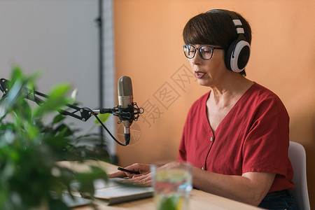 中年女电台主持人为在线节目制作播客录音  广播和 DJ 概念收音机打碟机笔记本技术麦克风电脑扬声器企业家互联网公告背景图片