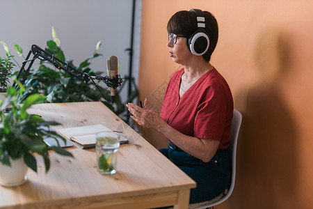 中年女电台主持人为在线节目制作播客录音  广播和 DJ 概念打碟机工作室公告娱乐笔记本商业扬声器耳机嗓音播音员背景图片