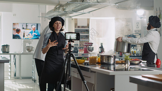 民族餐厅在电视节目节目中录制烹饪节目录像的女厨师背景