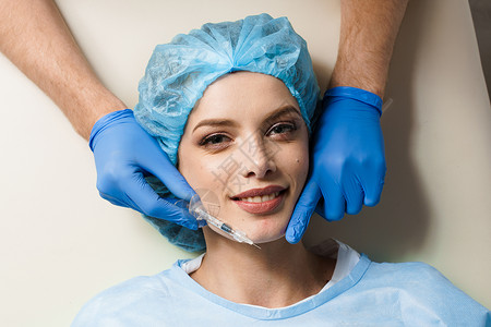 实用的手套为白种背景有吸引力的女孩注射增加口腔增生注射 整形外科医生在门诊部确实用嘴唇注射病人皮肤科治疗美容化妆品塑料手套皮肤女性程序背景