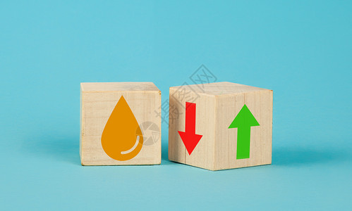 木头箭头木制立方体在蓝色背景上更改向上箭头和向下箭头和油符号 带向上箭头的油 带有红色和绿色箭头符号的转动木立方体的油价下跌或上涨概念背景