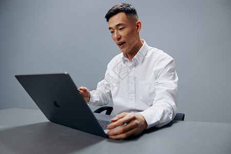 白衬衫亚洲男子工作笔记本电脑疲劳灰色背景图片