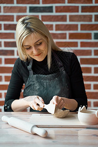 快乐的女人制作陶瓷陶器 用抹刀轻敲 自由职业者 商业女性的概念 手工艺品 赚外快 副业 把爱好变成现金 把热情变成工作背景