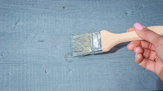 维持女孩用刷子画板 用灰色涂漆装潢建造木头工作桌子松树装修画笔地面工艺背景