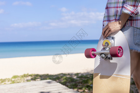 特写年轻女性拿着海滩背景的冲浪滑板 女性站在冲浪滑板上放松 享受带复制空间的热带海滩娱乐高清图片素材