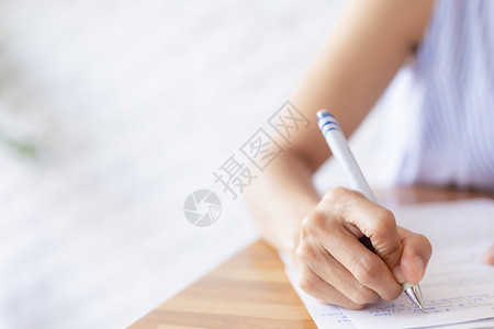 黄金地段手写字特写商业女性的手使用笔写文档纸 女性手在白纸上用蓝色钢笔写字 女人在一张纸上写信息笔记床单笔记本写作教育阅读学生商务合同女士背景