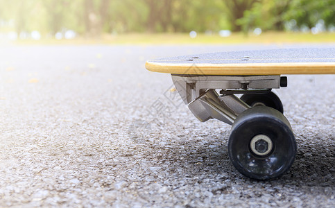 沥青形状早上在公园特写滑板 公园道路上滑板和轮子的头 体育概念活动滑冰车轮街道极限地面沥青文化蓝色滚筒背景