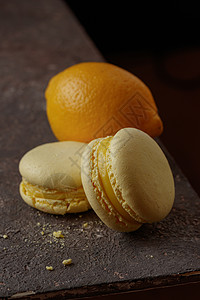 深色背景的柠檬马卡龙甜点食物黄色橙子水果饮食背景图片