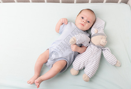 我有个梦关于你婴儿躺在婴儿床里 里面有一只泰迪熊 宝宝03个月大 冷静的孩子 一篇关于儿童玩具的文章 复制空间母亲尿布男生睡眠童年婴儿床毯子义背景
