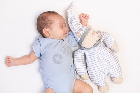 我有个梦关于你婴儿躺在婴儿床里 里面有一只泰迪熊 宝宝03个月大 一个平静的熟睡的婴儿 健康的婴儿睡眠 一篇关于儿童玩具的文章 毛绒玩具童年母背景