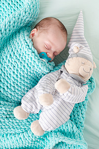 我有个梦关于你婴儿躺在婴儿床里 里面有一只泰迪熊 宝宝03个月大 一个平静的熟睡的婴儿 健康的婴儿睡眠 一篇关于儿童玩具的文章 毛绒玩具婴儿床背景
