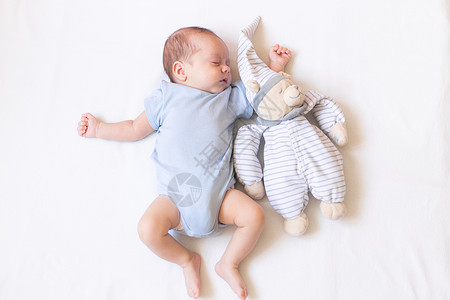 我有个梦关于你婴儿躺在婴儿床里 里面有一只泰迪熊 宝宝03个月大 一个平静的熟睡的婴儿 健康的婴儿睡眠 一篇关于儿童玩具的文章 毛绒玩具母亲男背景