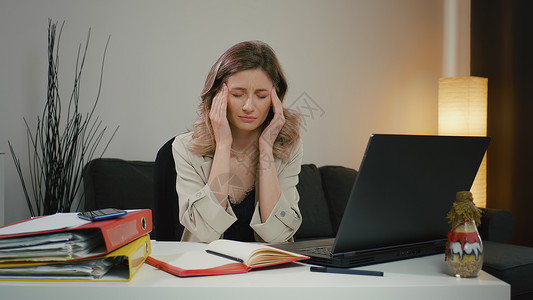 坐姿不端正疲劳的女人被笔记本电脑工作所压倒 头痛不堪自由职业者职场强人视镜感觉眼睛女性商业技术压力背景