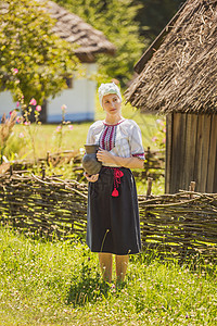 妇女穿着乌克兰民族服装 手里拿着一壶酒背景
