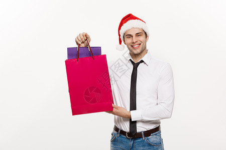 圣诞节概念英俊的商务人士庆祝圣诞快乐和新年快乐戴圣诞老人帽子和圣诞老人红色大袋子零售商务男性购物狂礼物盒购物者人士购物礼品盒市场背景图片