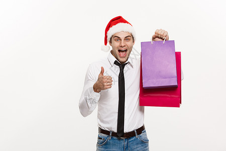 圣诞节概念英俊的商务人士庆祝圣诞快乐和新年快乐戴圣诞老人帽子和圣诞老人红色大袋子店铺盒子假期展示市场礼品盒微笑男人庆典男性背景图片