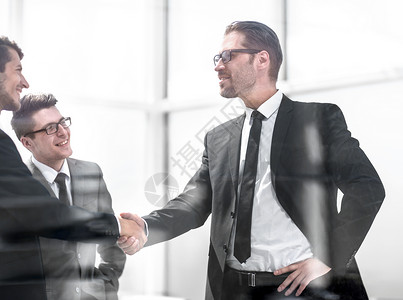 在现代办公室与商业伙伴进行握手工作男性男人团体成功手势交易公司协议职员背景图片