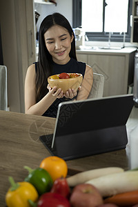 店招素材在线制作健康沙拉和在数字平板电脑上寻找在线食谱的素材 这些都由一位年轻女性制作背景