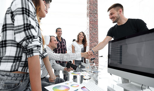 在创造性的办公室里 和同事握手合作设计师男人工作室工作经理商务桌子伙伴职员看着高清图片素材