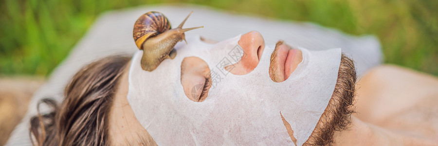 蜗牛头年轻人用蜗牛粘液做面膜 蜗牛在面罩上爬行男士美容男人温泉皮肤鼻涕虫面具化妆品格式动物背景
