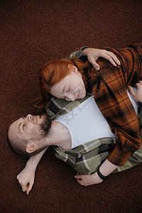 爱人躺在红色的遮罩和拥抱上衬衫幸福热情两个人公园乐趣亲热享受男性喜悦图片