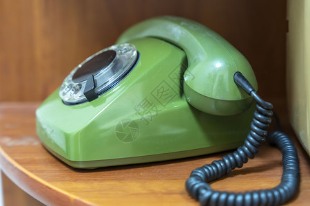 绿色旧用电话 有旋转拨号 手机放在架子上图片