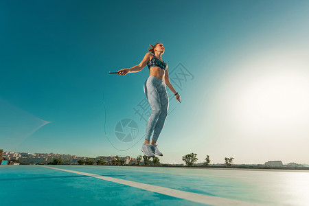 女青年运动员培训在灵活梯子上跳跃 协调户外协调天空运动横幅运动装跳绳训练身体成人肌肉健美背景图片
