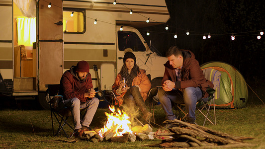 旅游车素材一群朋友在秋天寒冷的夜晚聚集在营地大火周围帐篷团体火焰朋友们乐趣森林胡子星星时间旅游背景
