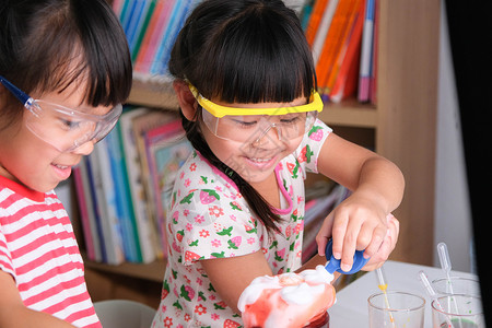 实训教室孩子们在教室里学习和做科学实验 两个小姐妹在进行家庭教育的科学实验 为孩子们在家进行简单有趣的科学实验滴管孩子课堂女孩液体烧瓶实背景