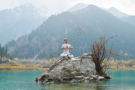 一个年轻人练瑜伽练习男人躯干站姿文化专注身体山脉喜悦青年石头图片
