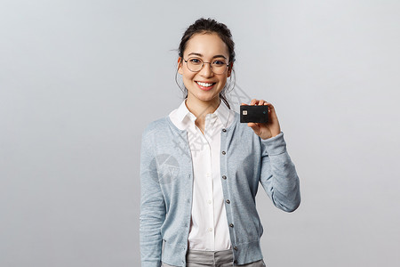 购物不用愁技术 在线购买和财务概念 戴眼镜 帅气的亚洲女性 不用现金使用信用卡支付 在网上支付 在家购物商业学生金融学习卡片互联网女孩微笑背景