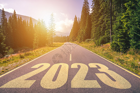 空荡荡的柏油路和 2023 年新年概念 在山区一条空旷的道路上行驶到即将到来的 2023 年 成功和消磨时间的概念背景图片