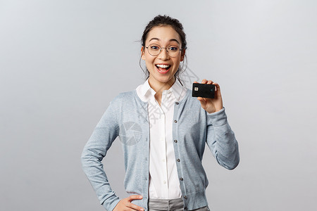 技术 在线购买和财务概念 快乐开朗 友好的戴眼镜的亚洲女性描述了好银行的特点 推荐用信用卡购买互联网 微笑着惊讶导师女孩混血女朋背景图片